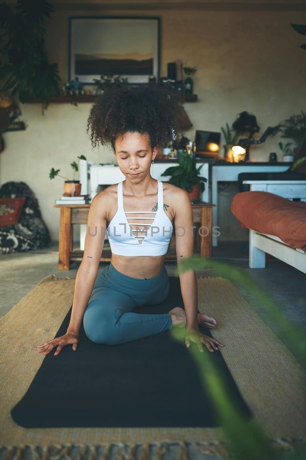 Shot of a young woman doing yoga in her living room