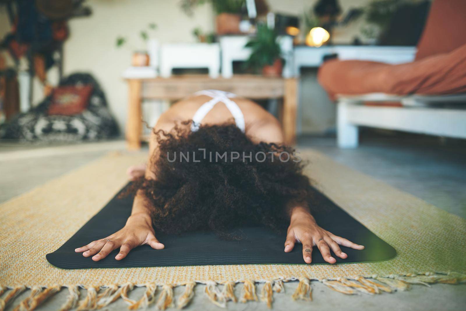 Cropped shot of a woman stretching on her yoga mat