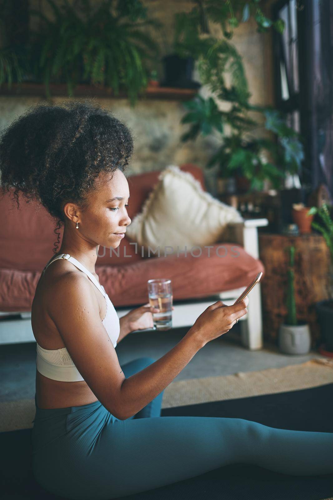 Shot of a young beautiful girl in her sportswear browsing on her smartphone