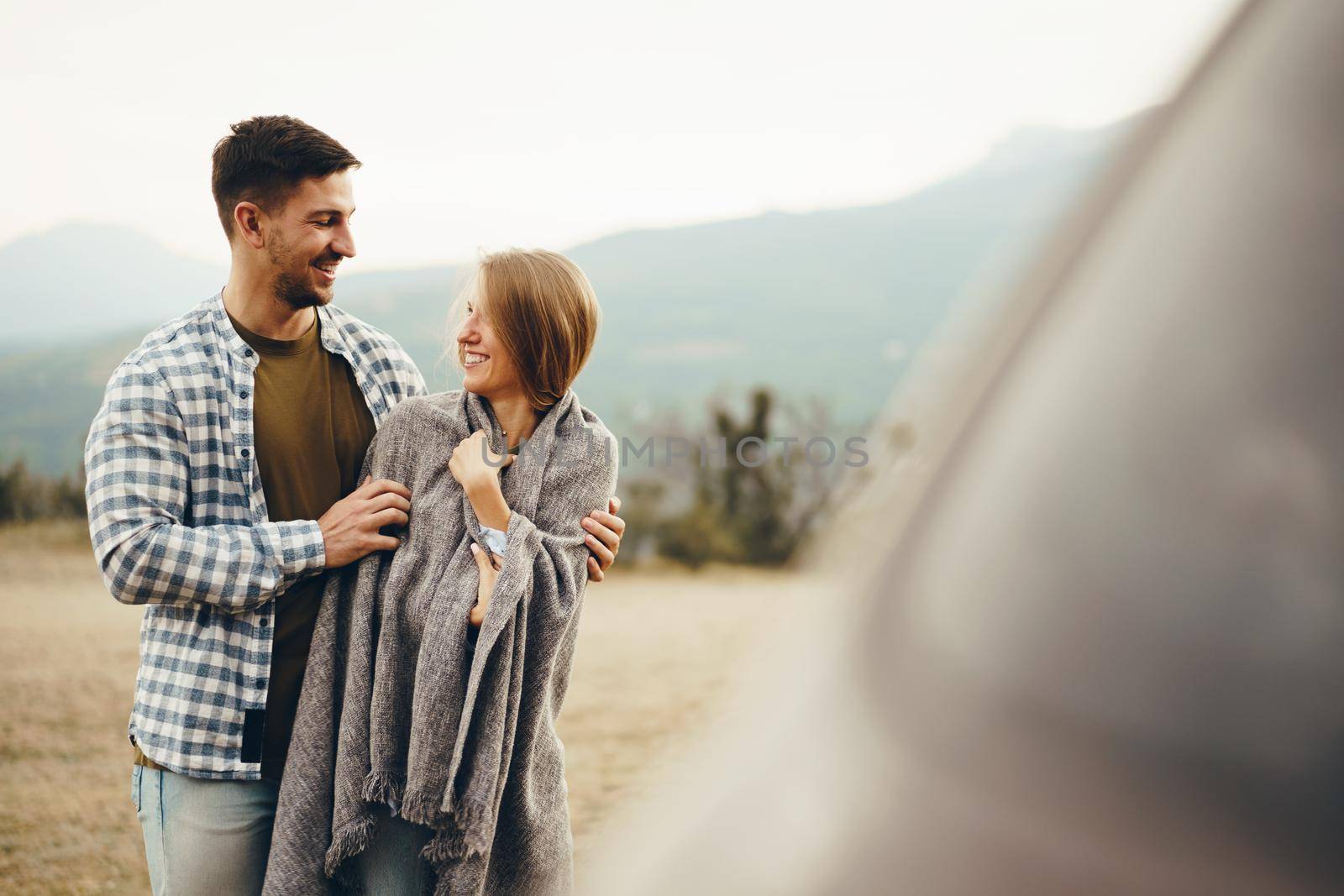 Happy loving couple hiking and hugging in mountains, close up