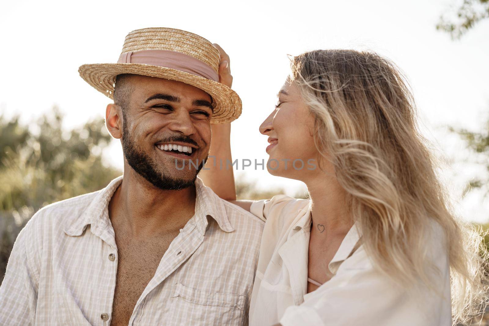 Young couple sitting next to each other on beach, close up