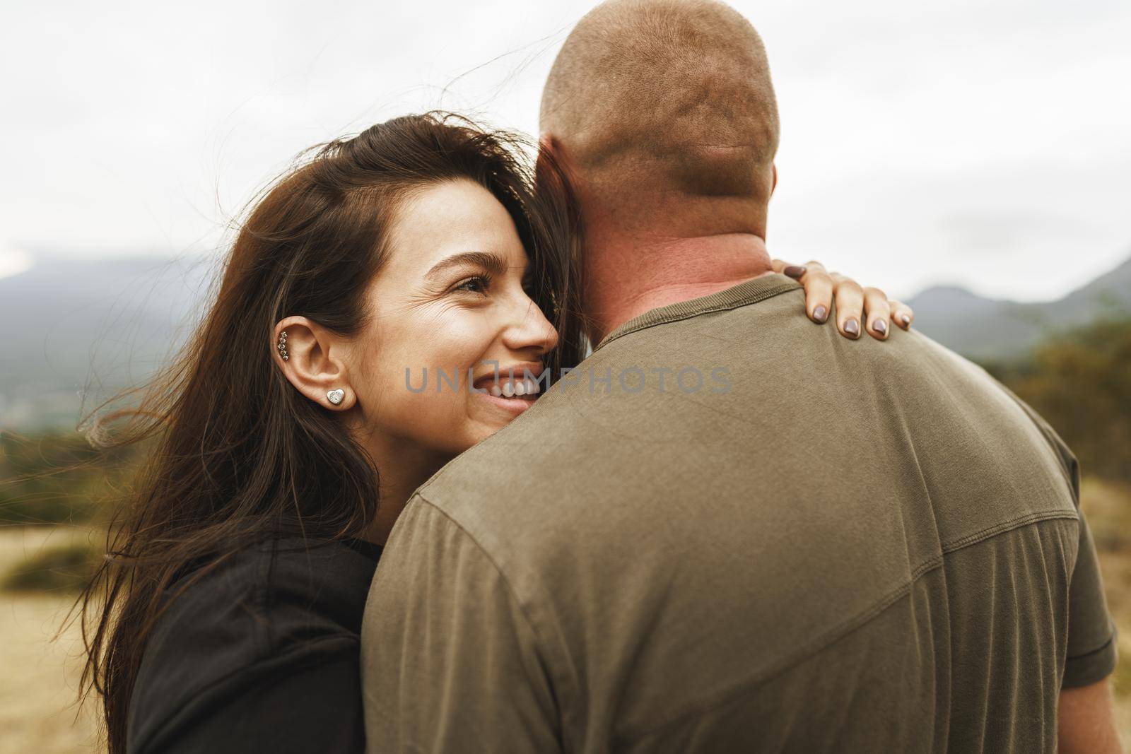 Happy couple in love hugging smiling and having fun in the mountains on foggy day