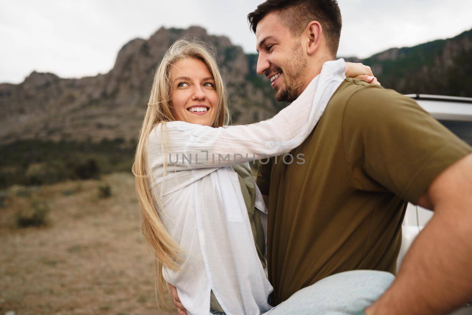 Happy loving couple hiking and hugging in mountains, close up