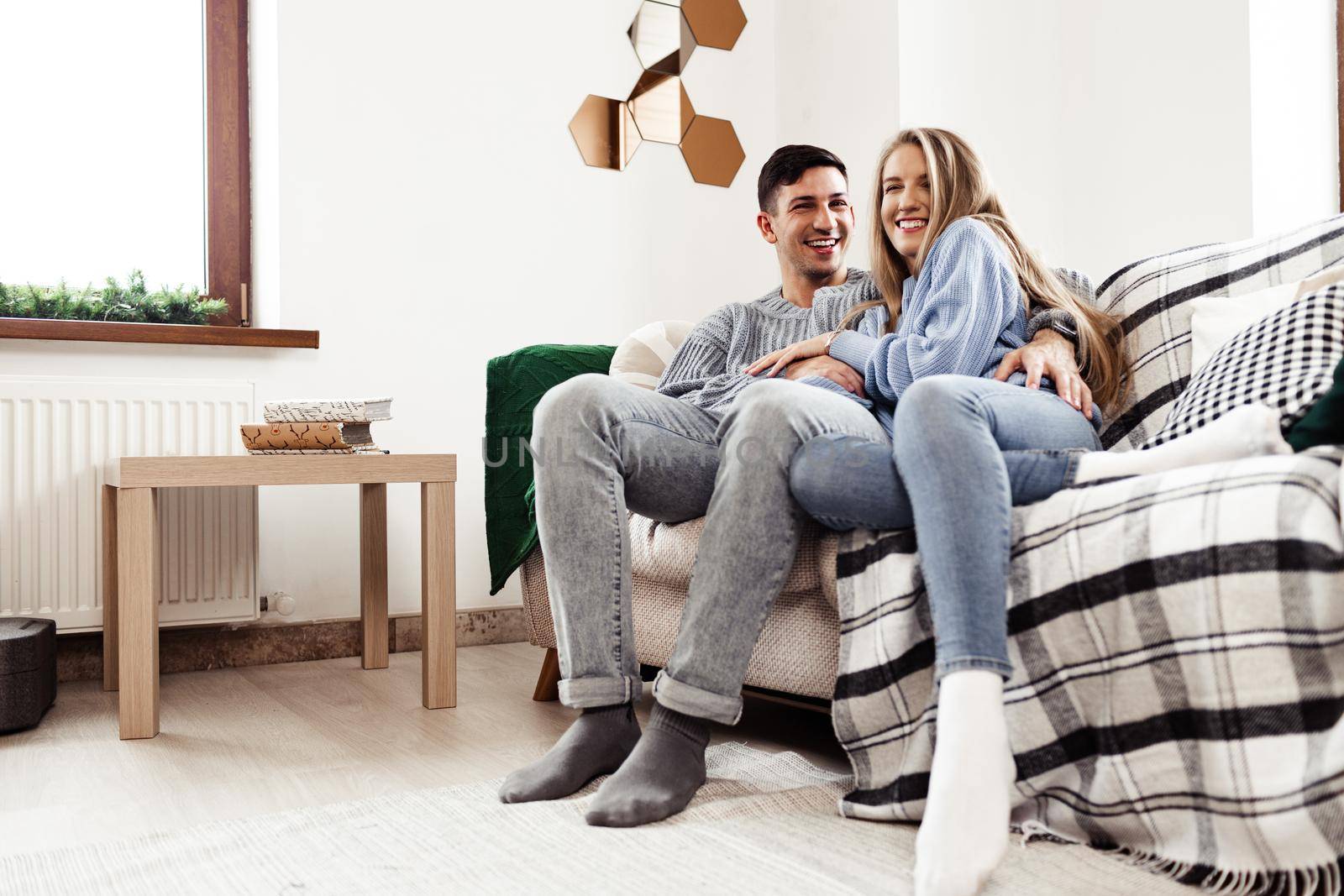 Happy young couple sitting on sofa in living room