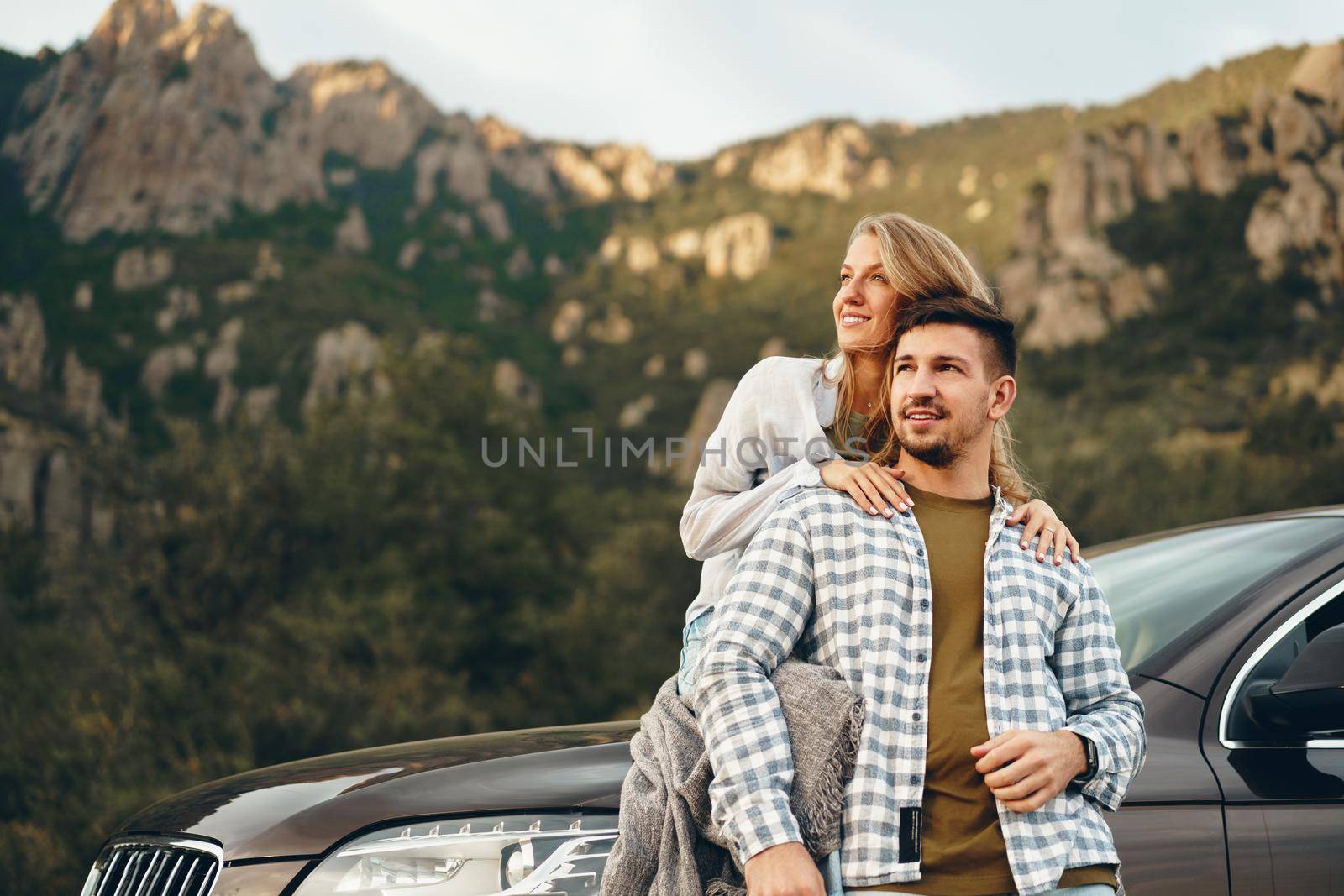 Young couple is on romantic trip to the mountains by car by Fabrikasimf