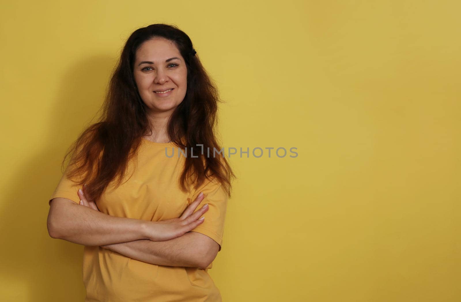 Belt portrait of a woman 30-35 years old in T-shirt on yellow studio background. by gelog67