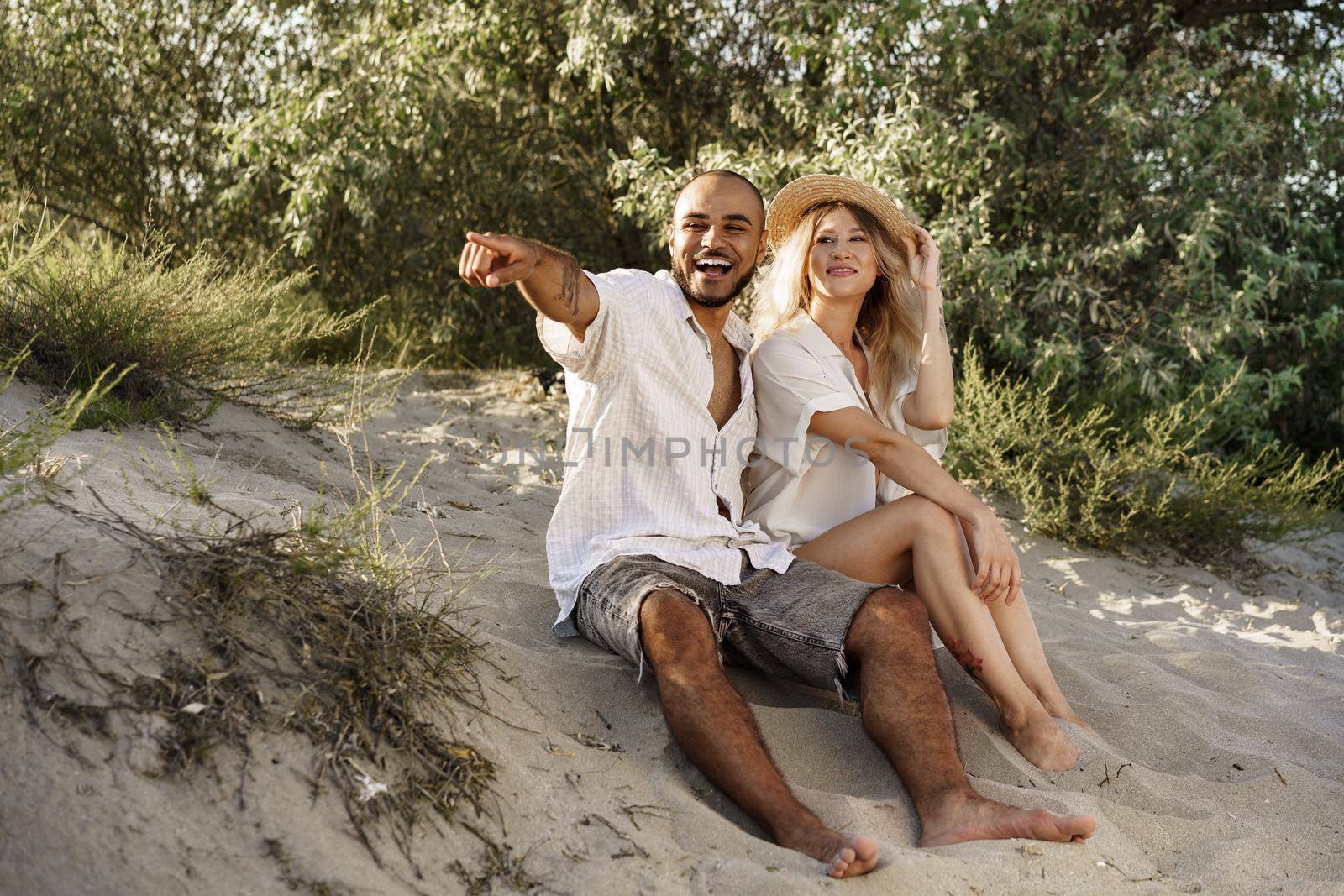 Young couple sitting next to each other on beach, close up
