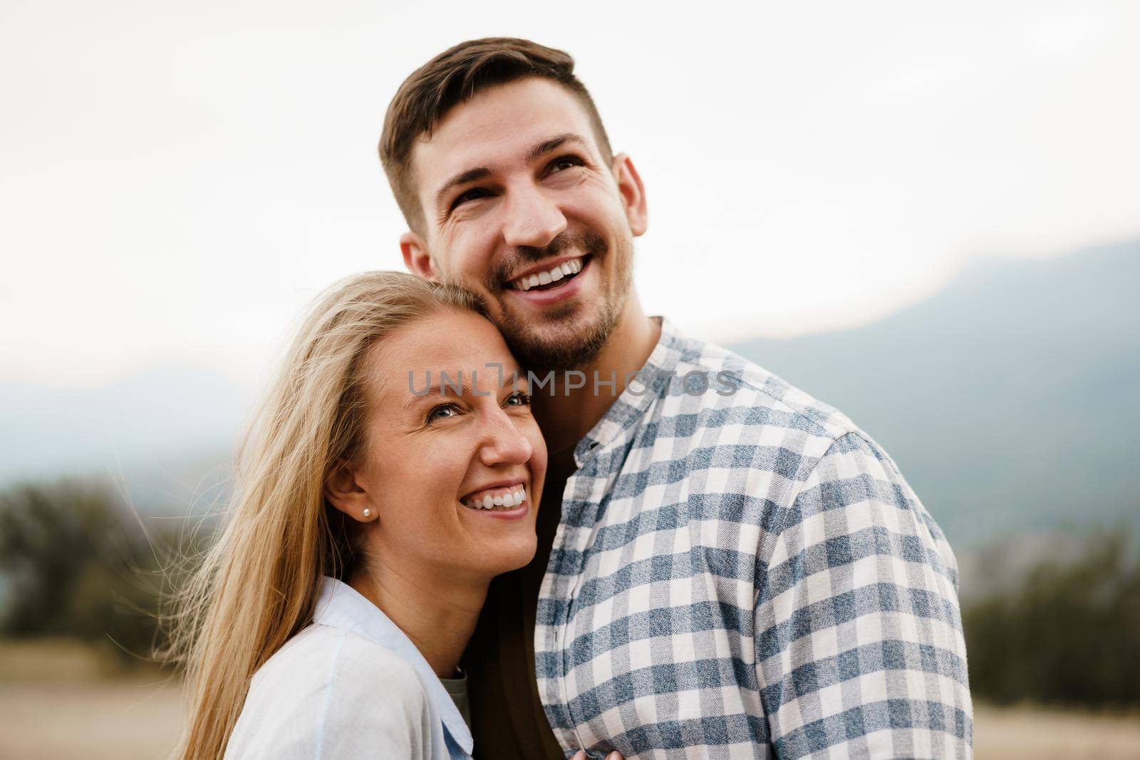Happy loving couple hiking and hugging in mountains, close up