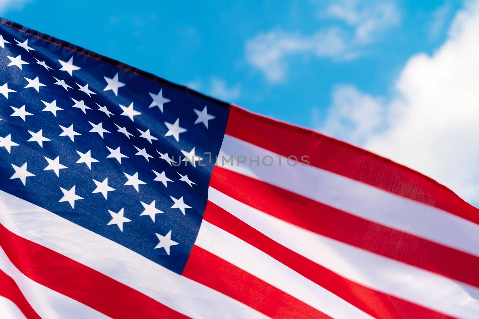American flag waving in the wind against blue sky