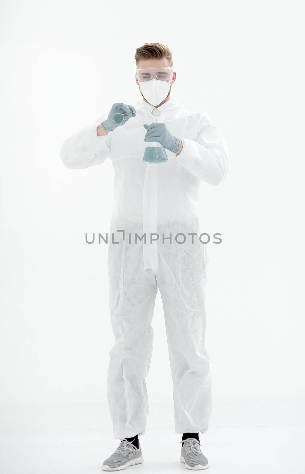 scientist in a protective suit examines the blue liquid by asdf