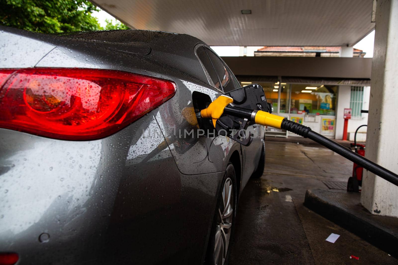 The car is refueling at the gas station. Refueling automobile with gasoline or diesel with a fuel dispenser. by RecCameraStock