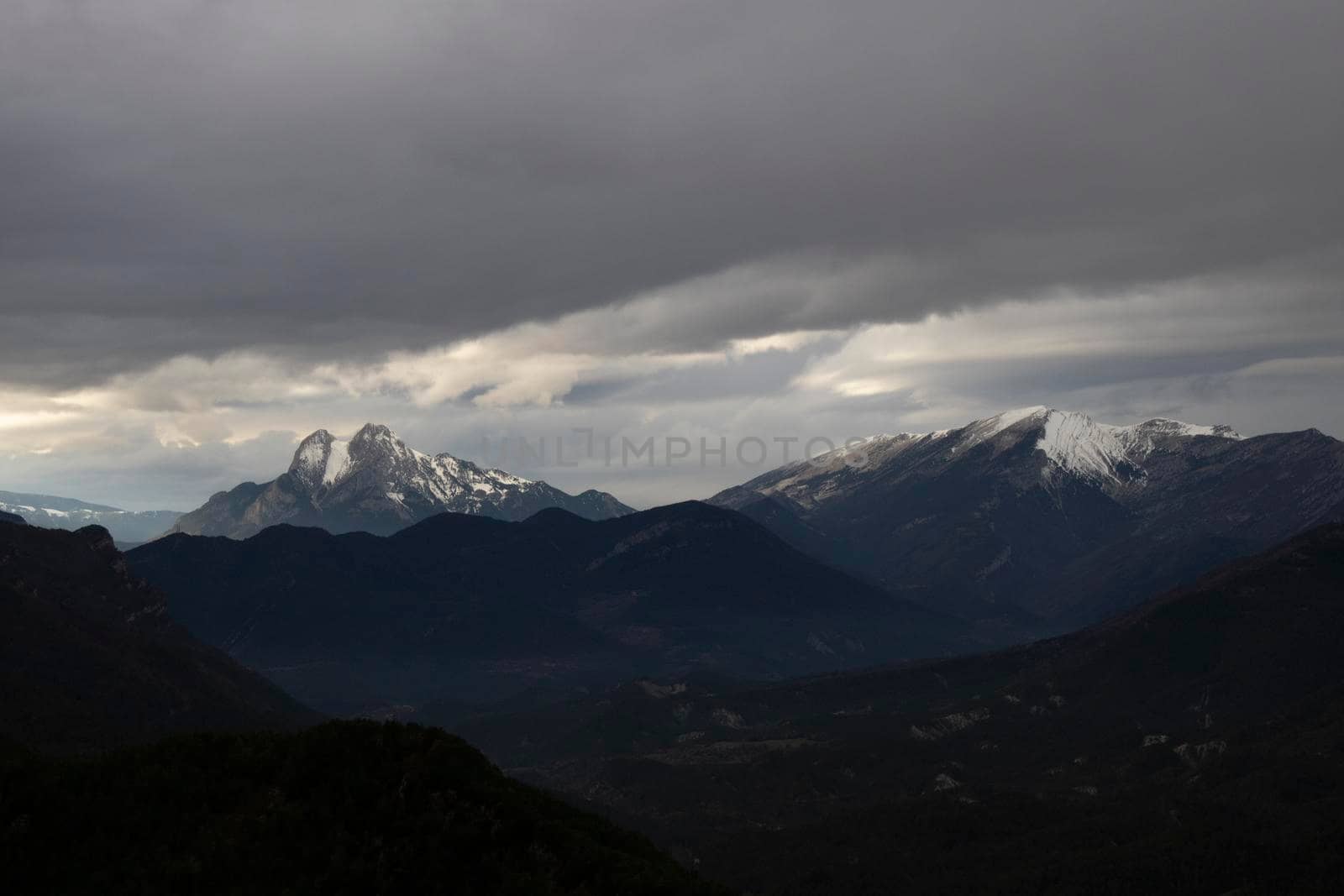 Landscape showing a couple of snowy mountains, one of them called Pedraforca, under a cloudy sky