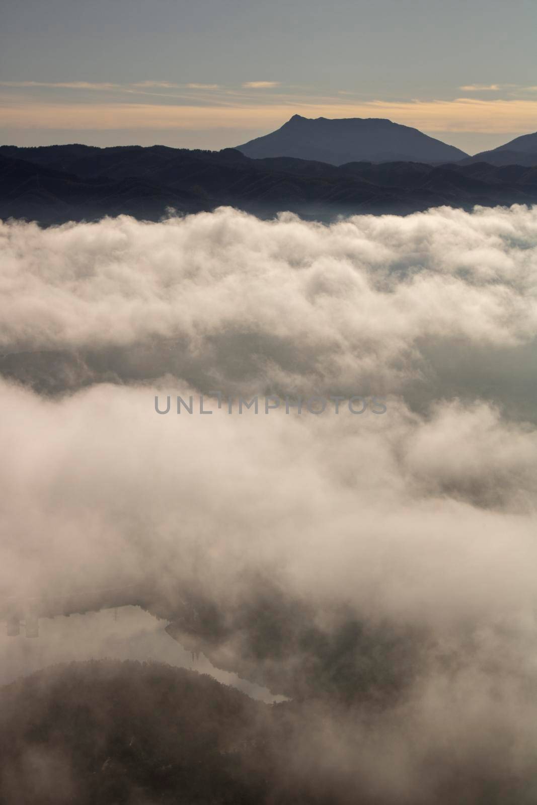 Landscape partially covered by a layer of fog under a blue sky in Tavertet town in Catalonia