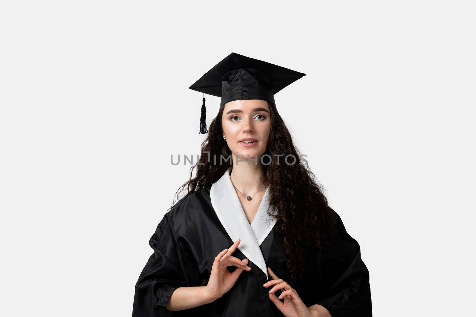 Distance learning online. Study at home. Graduation from college. Graduate in black robe smile on white background. Funny woman smiling after successful finish university and complete master degree
