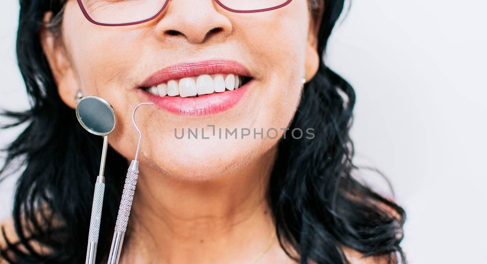 Close up of perfect smile and dentist tools on white background, Perfect smile of woman with dentist tools, Concept of perfect smile and dentist tools
