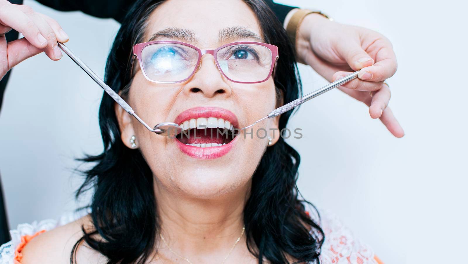 Close up of dentist with patient, dentist performing root canal treatment on patient, dentist performing dental checkup, Patient checked by dentist by isaiphoto
