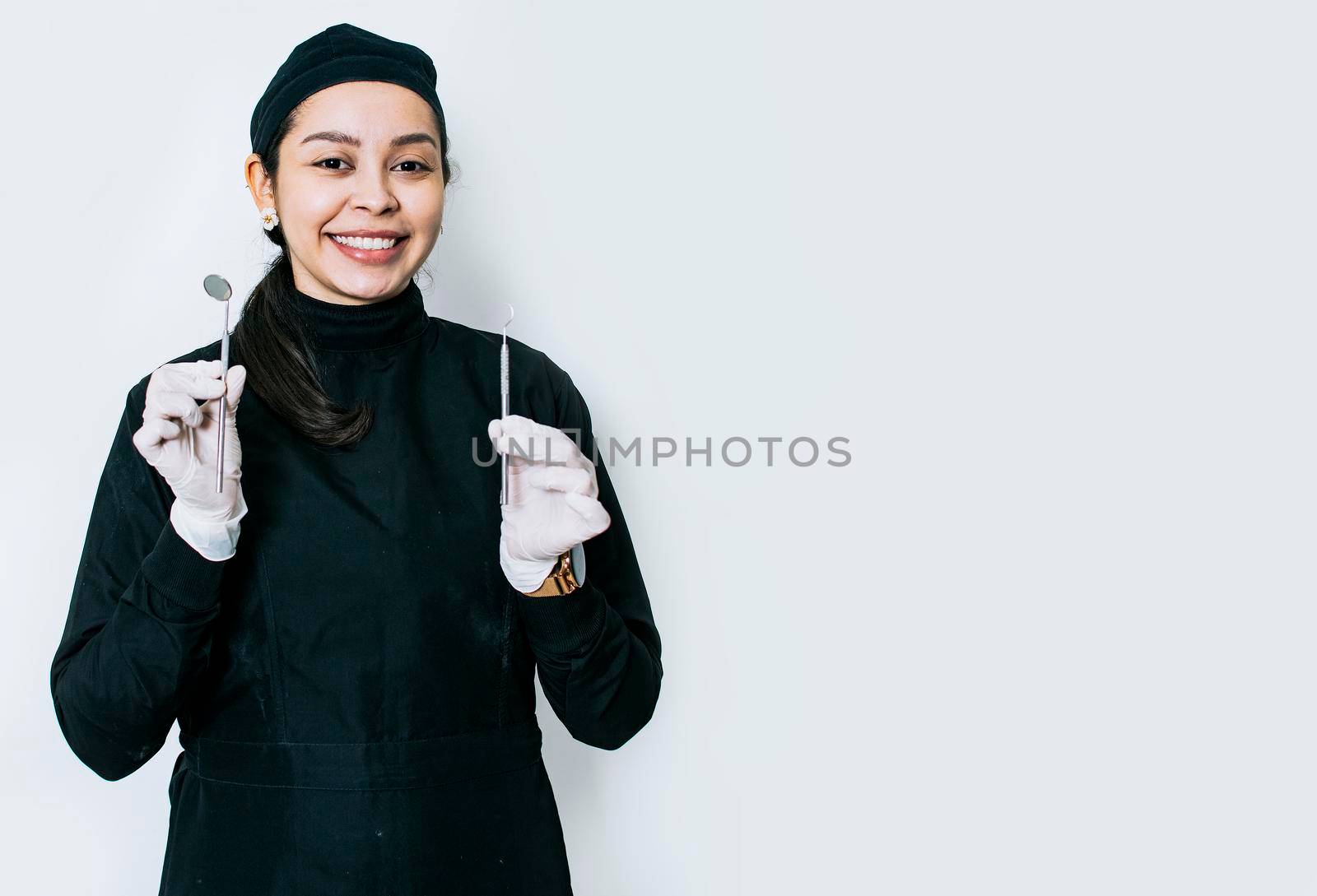 Portrait of a dentist with dental tools, portrait of a female dentist with mirror and dental probe, isolated dentist woman with dental tools