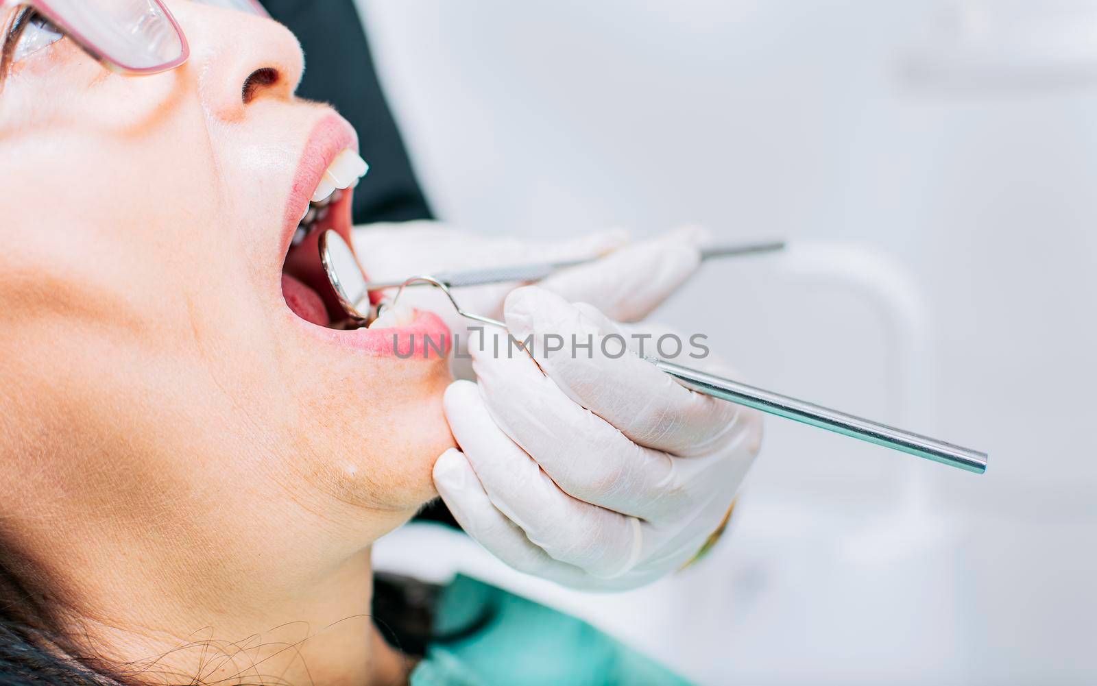 Dentist checking patient's mouth, Close up of patient checked by dentist, close up of dentist's hands checking patient's mouth, Dentist performing stomatology