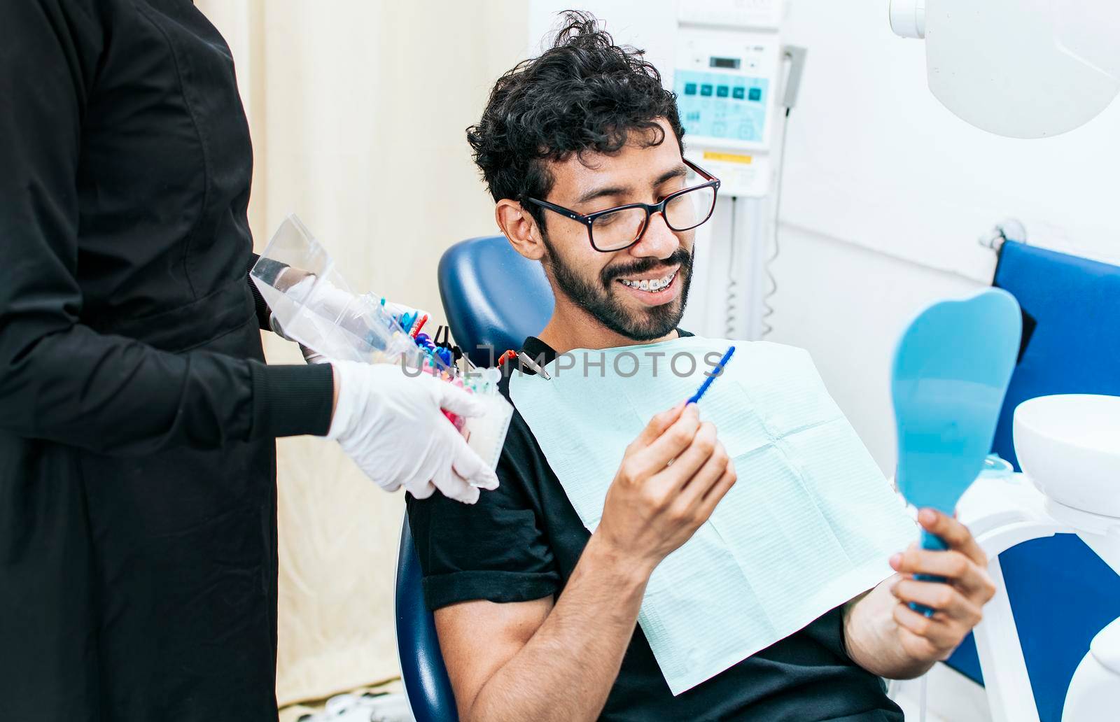 Patient with dentist choosing dental braces, Dentist with patient choosing metal braces, Patient with dentist choosing rubber band