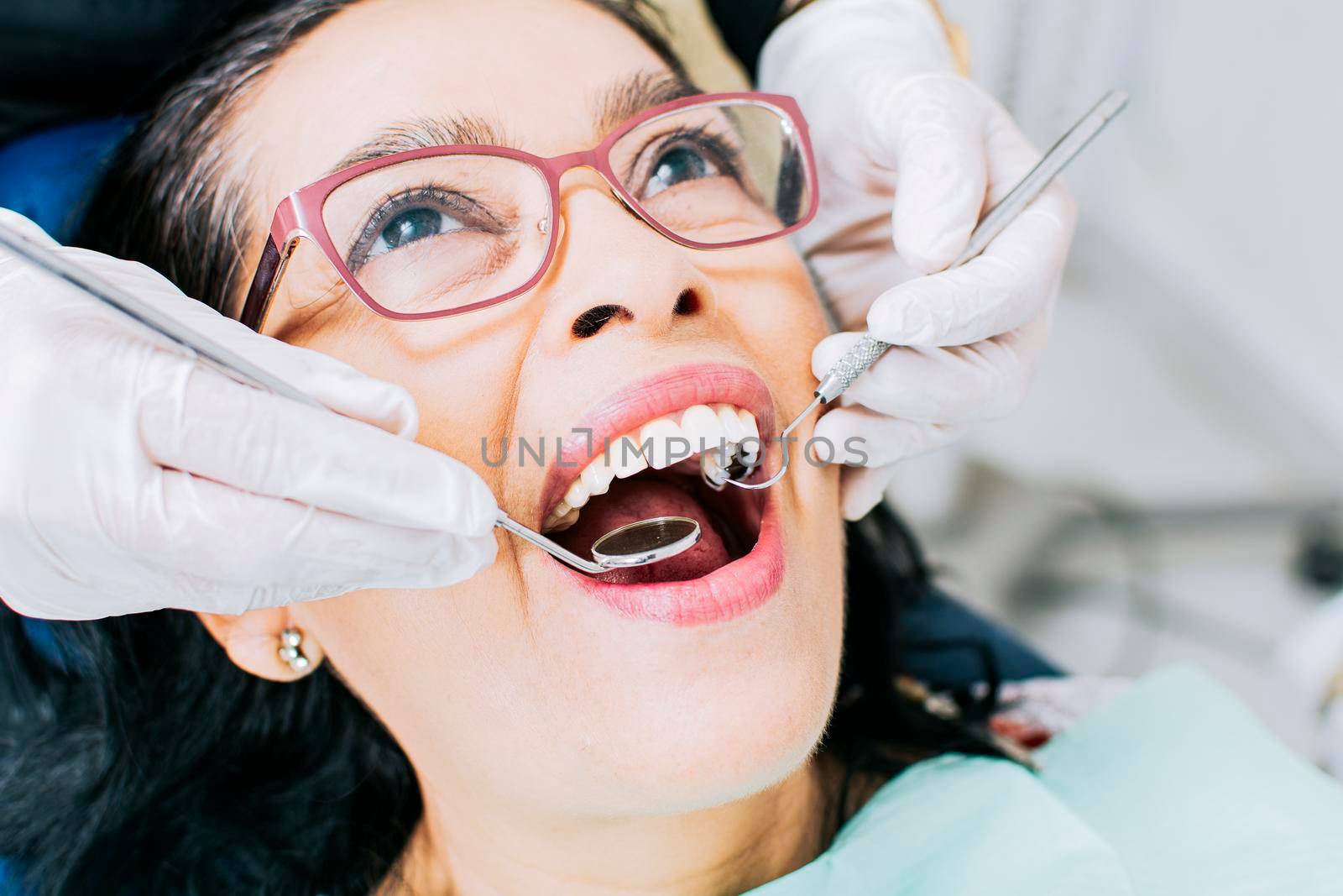 Patient checked by dentist, close up of dentist with patient, dentist performing root canal treatment on patient, dentist performing dental checkup by isaiphoto