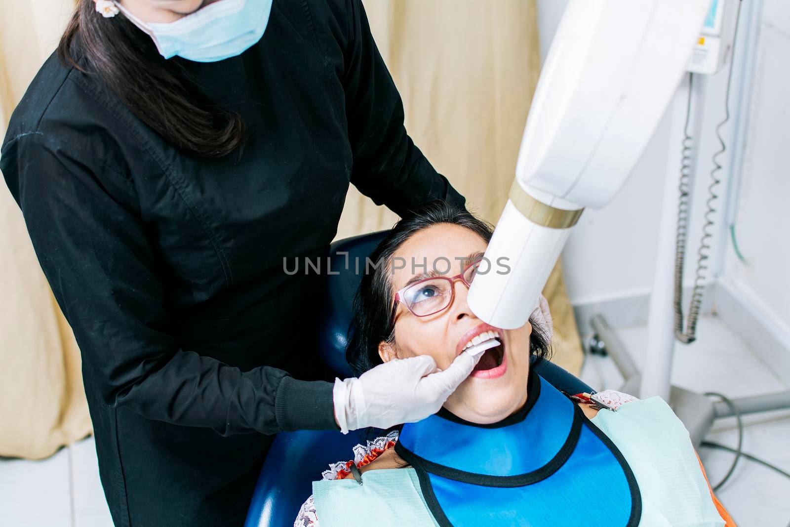 Female dentist doing dental x-ray, Female dentist doing x-ray to patient, female dentist doing dental x-ray, dental x-ray concept