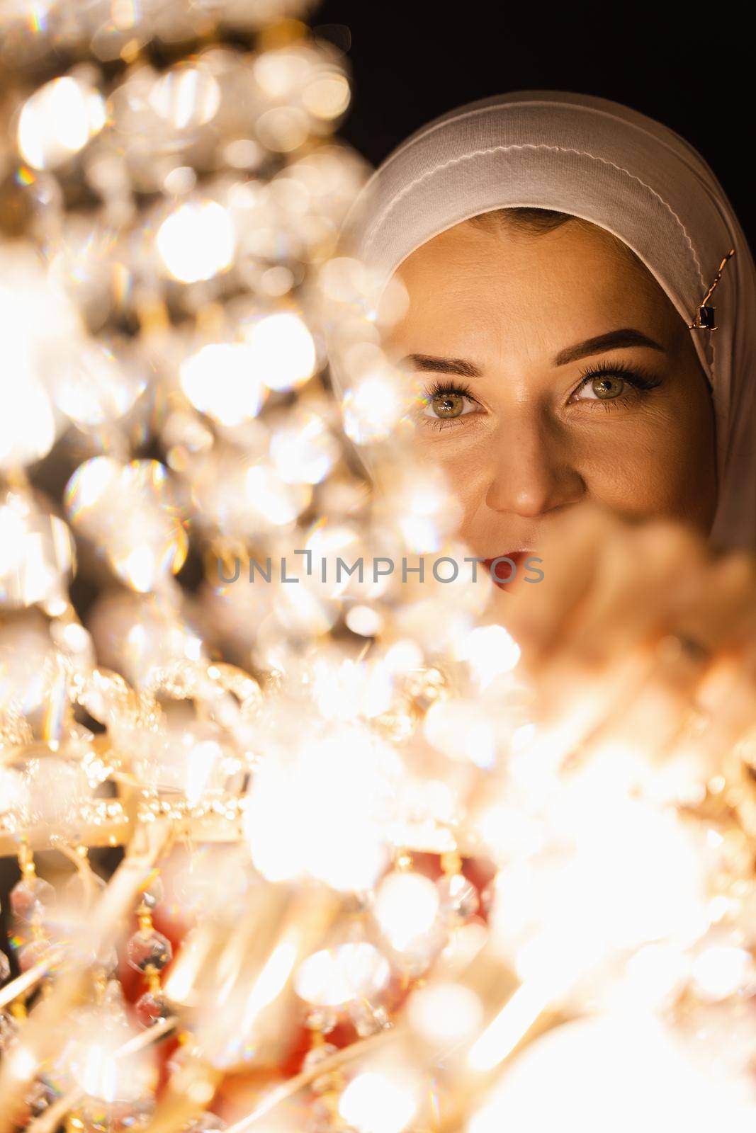 Fashion muslim model near big expensive chandelier. Islamic religion. by Rabizo