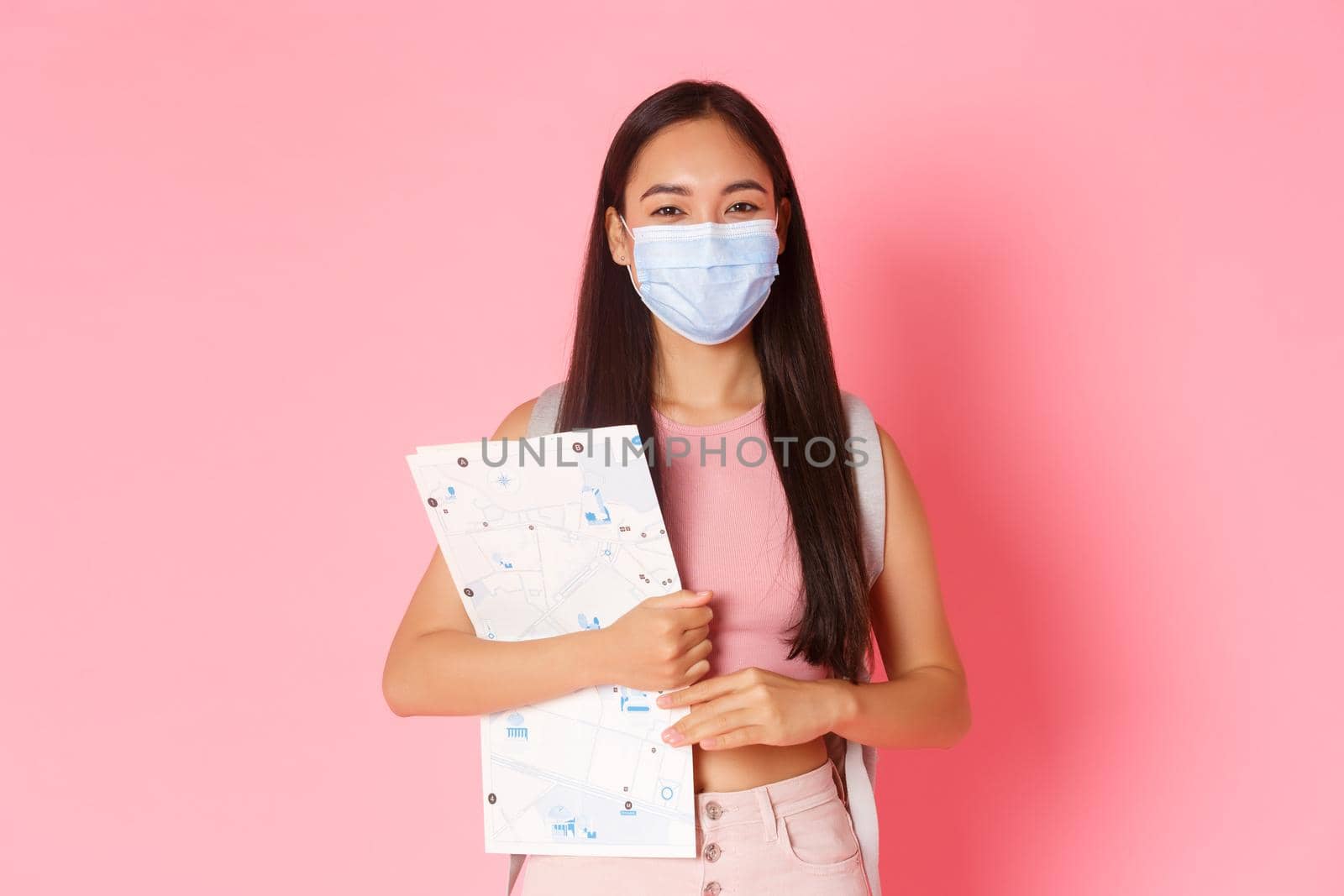 Safe tourism, travelling during coronavirus pandemic and preventing virus concept. Cute asian girl travel abroad, tourist in medical mask with map going sightseeing, social distancing during journey by Benzoix