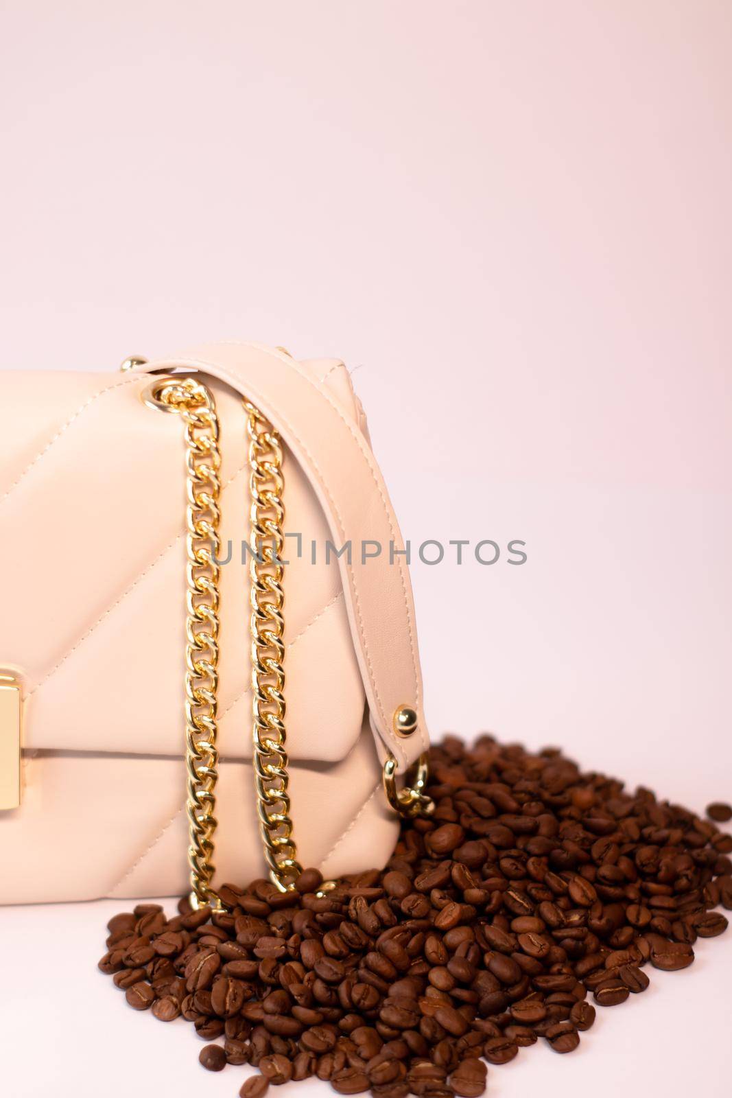 fashion beige leather woman handbag with gold chain with coffee beans nearby isolated on white background. Product photography. bags and purses for women by oliavesna