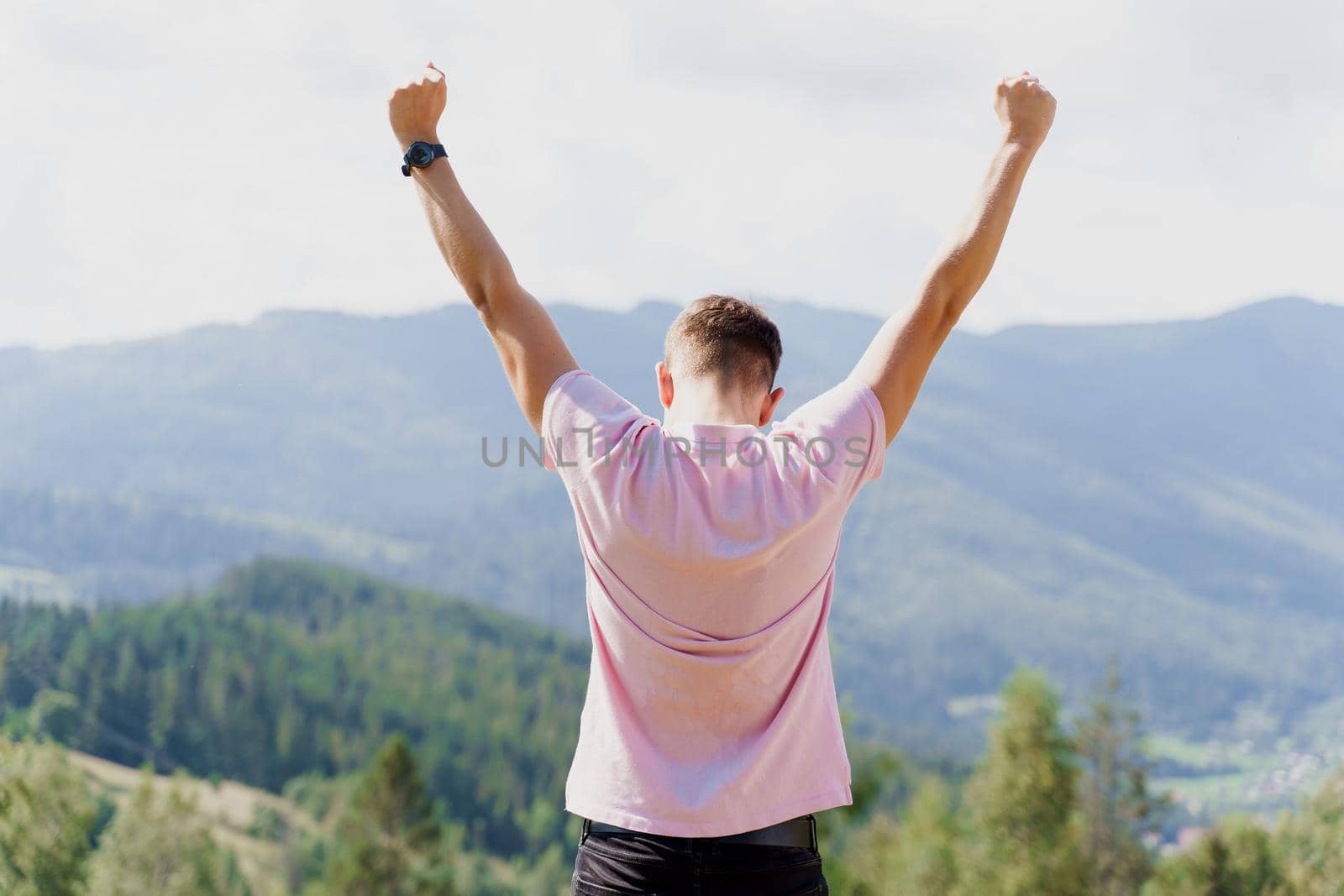 Tourism travelling in Ukraine. Man girl raised her hands up and enjoys the mountain hills view. Feeling freedom in Karpathian mountains.