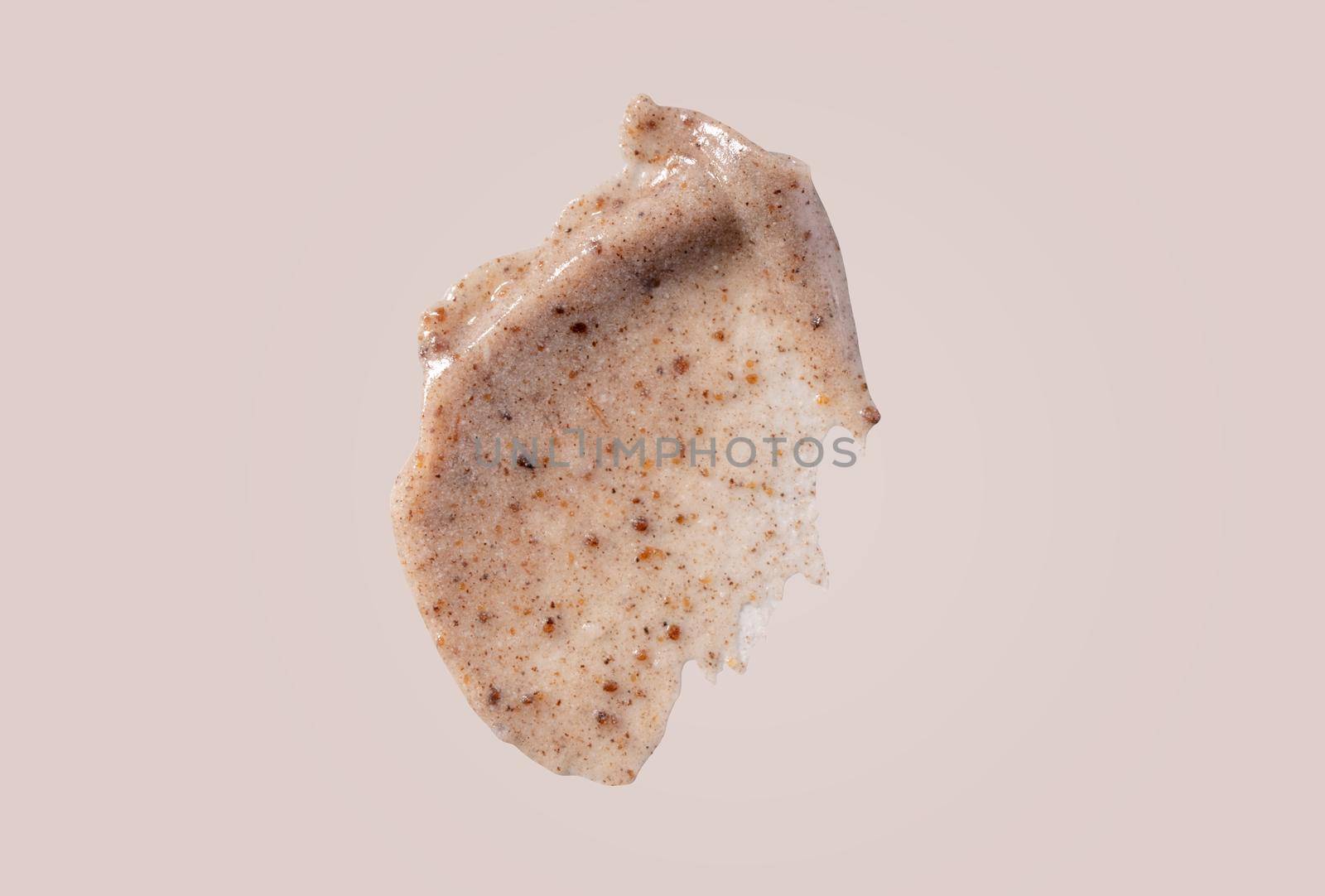 Scrub smear swatch isolated on beige background. Peeling cream smudge with exfoliating particles. Cosmetic skincare product with abrasive particle sample, gentle nude scrub texture isolate.