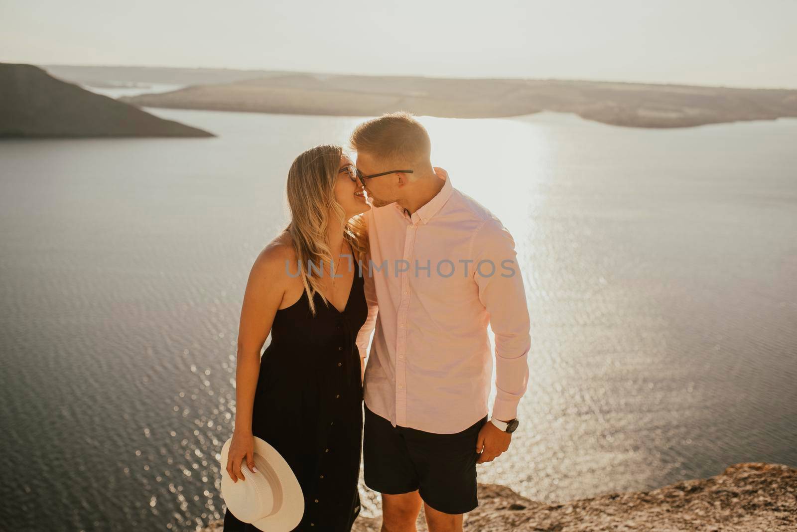 man and woman in love walk on a mountain above a large lake sea by AndriiDrachuk