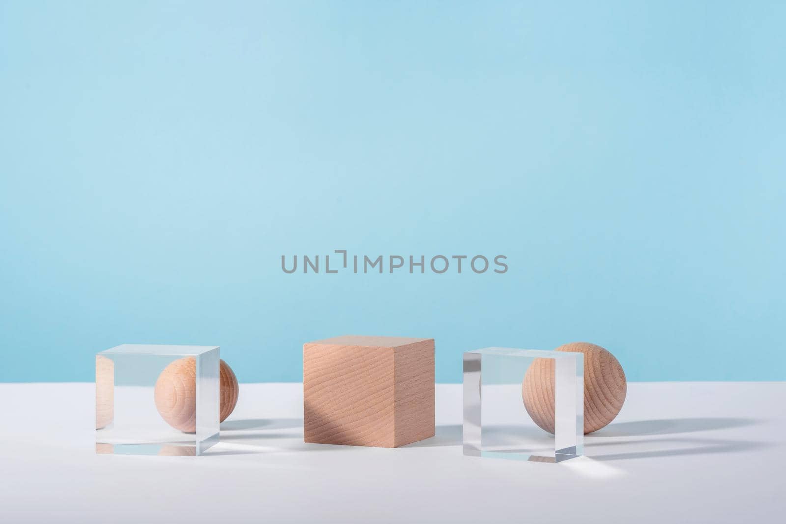 Creative geometric product stage mock up, cosmetics display platform, product advertising, geometric stand. Wooden and glass cube podium, sphere on blue background for cosmetic or jewellery by photolime