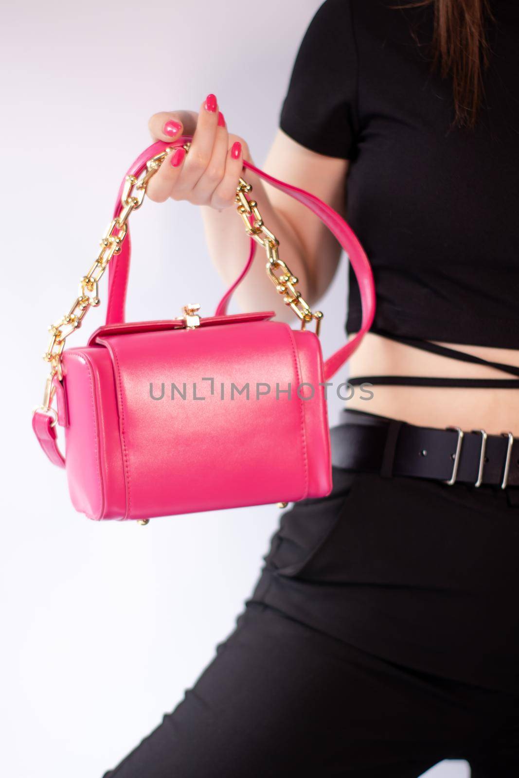 womans hand holding a pretty little pink handbag. Product photography. stylish handbag and purse for women
