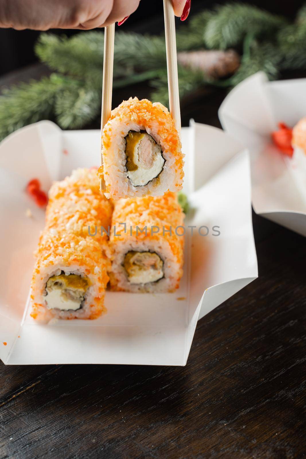 Sushi roll on the food delivery plate. Roll with salmon, mango and soft cheese