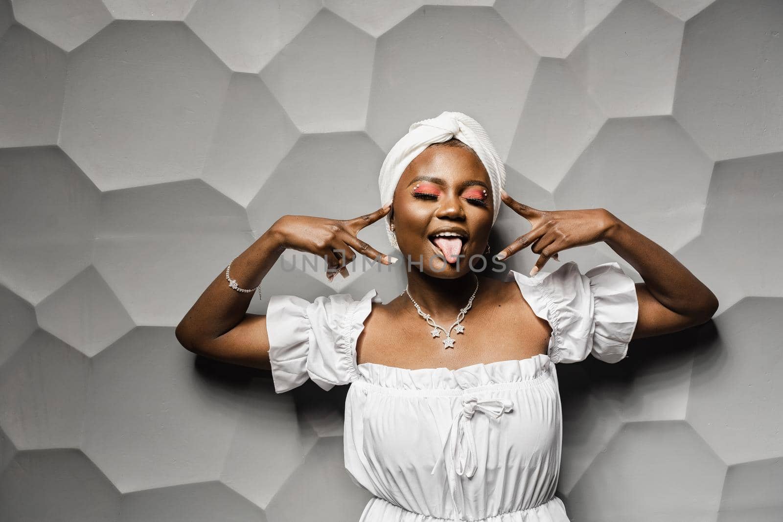 Black muslim woman holding up 2 fingers have party. African girl is celebrating her birthday and having fun,