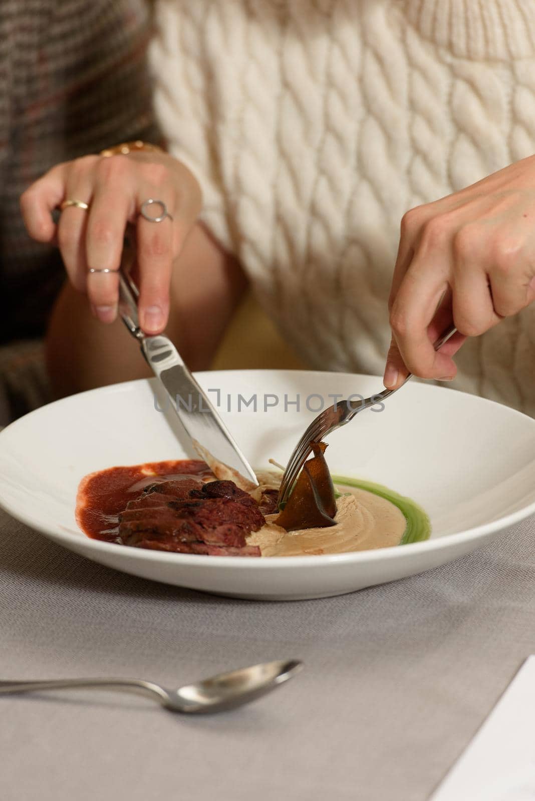 woman eating veal tenderloin with fried mashed potatoes and micro green by Ashtray25