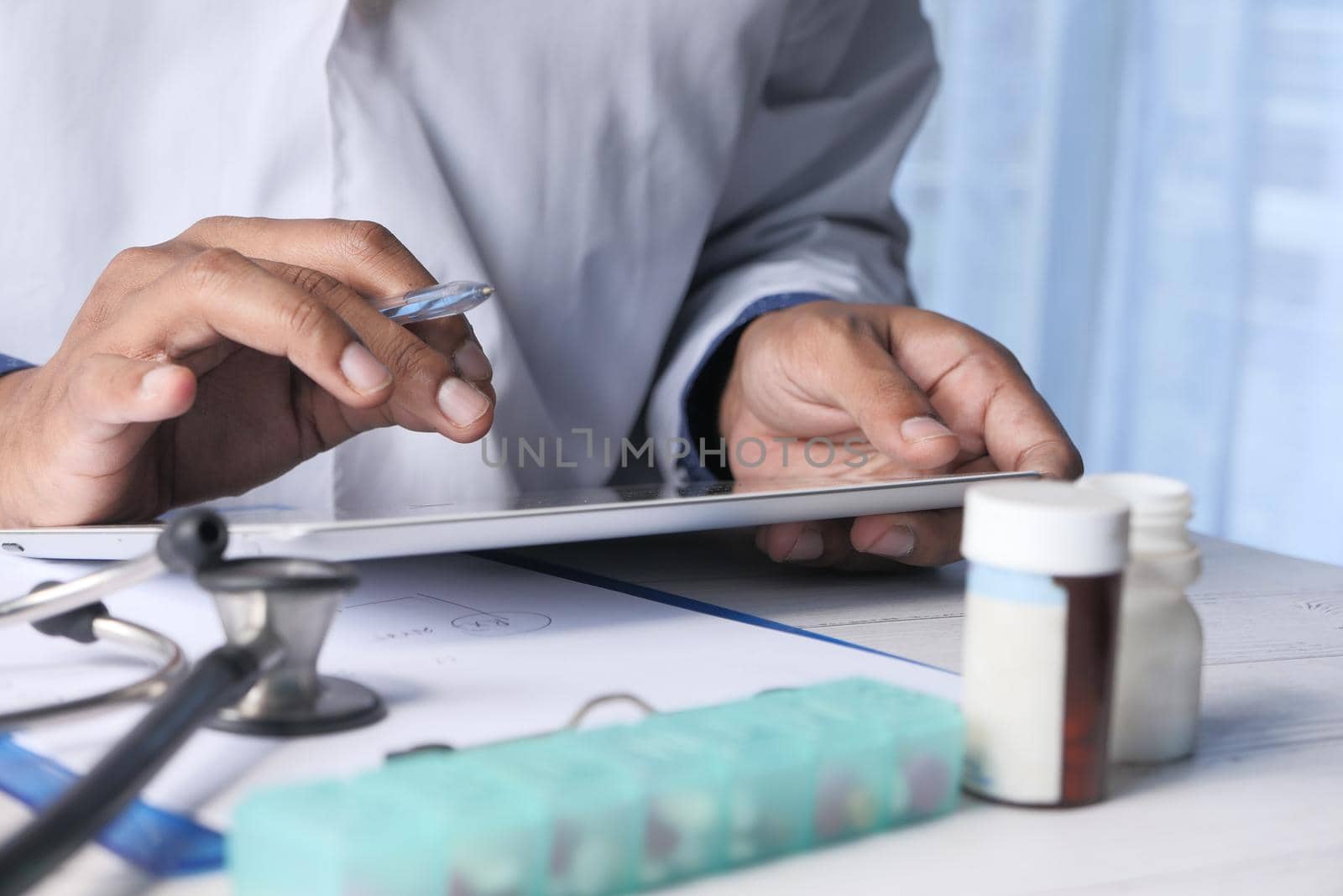 doctor in white coat is using a digital tablet,