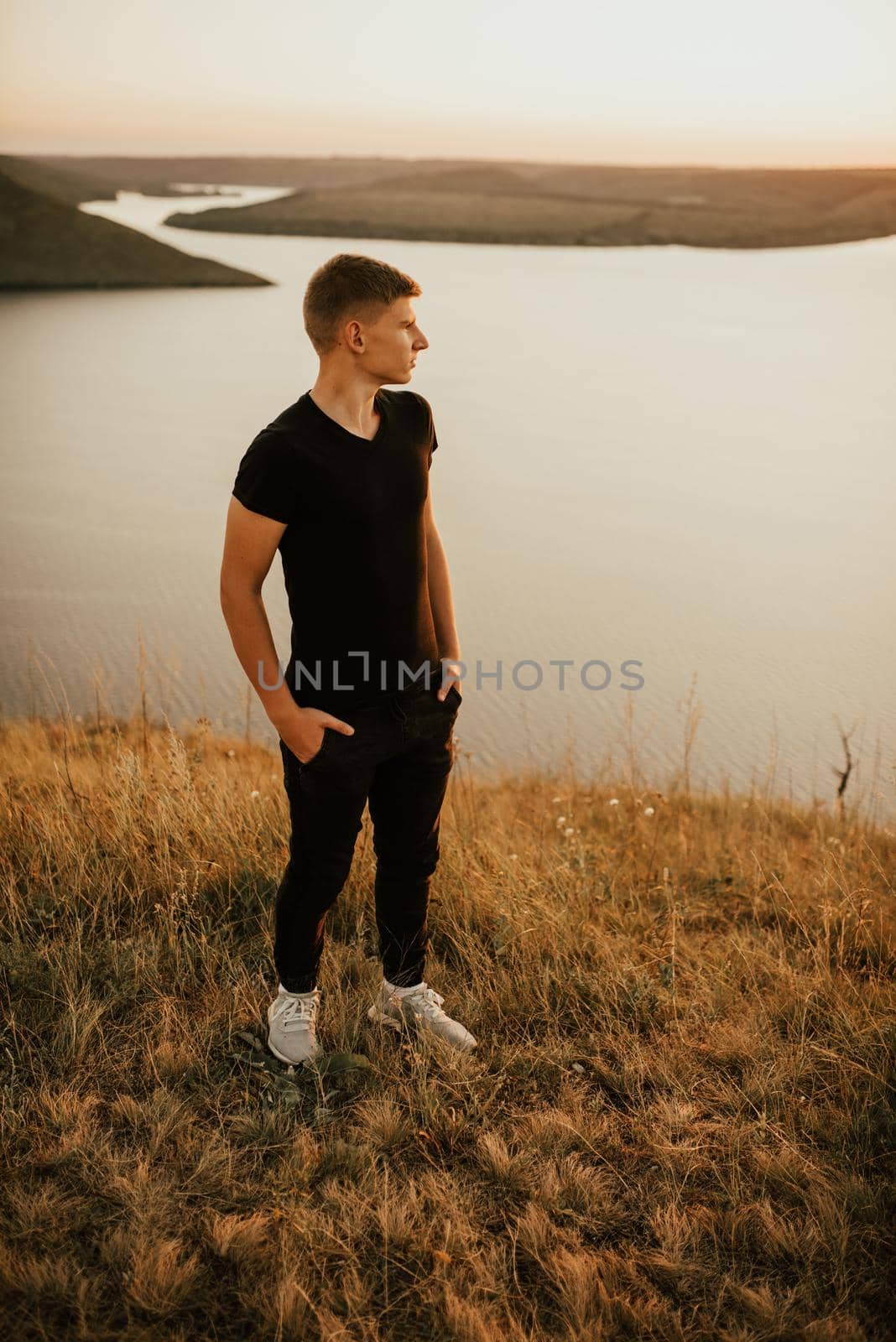 Bakota, Ukraine - 08.12.2020: A young athletic man in black casual clothes by AndriiDrachuk