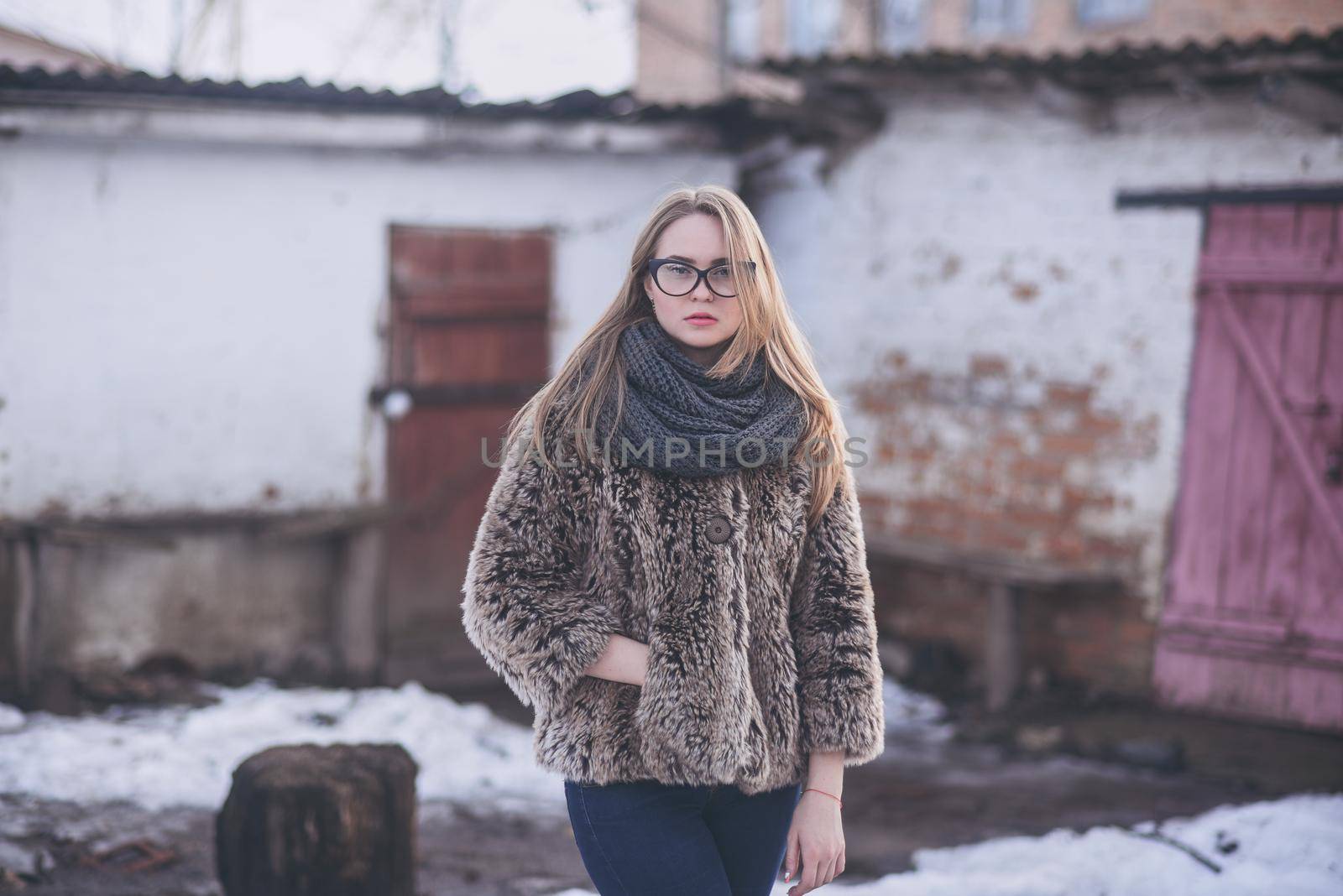 Girl blonde in glasses in fur coat in winter by AndriiDrachuk