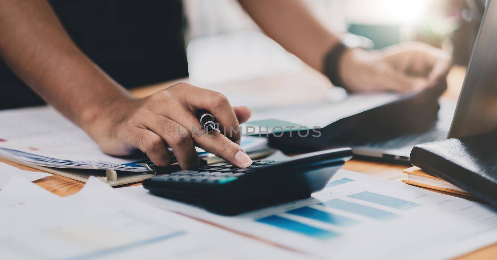 Close up accountant working on desk using calculator for calculate finance report at home office.