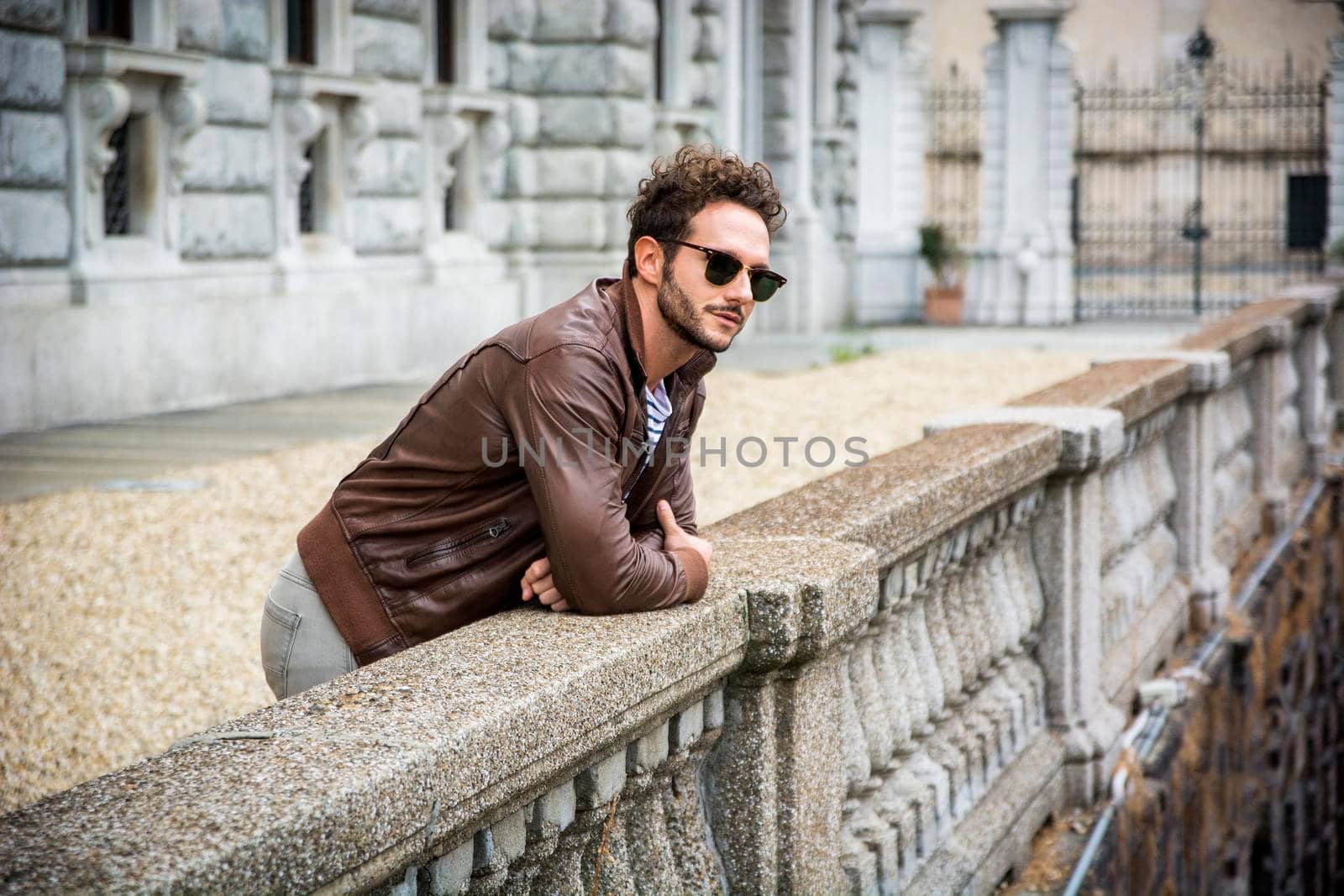 Attractive young man outdoor wearing leather jacket, in European city, Turin in Italy