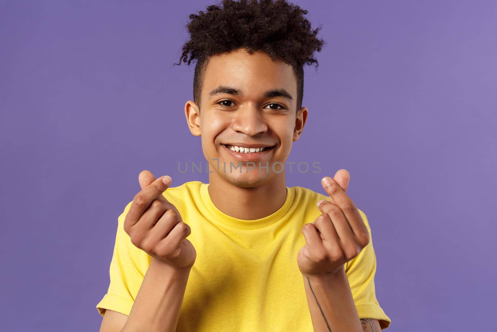 Close-up portrait of lovely cute young man with afro haircut, showing korean heart finger signs and smiling, express his love and sympathy towards person, stand purple background by Benzoix