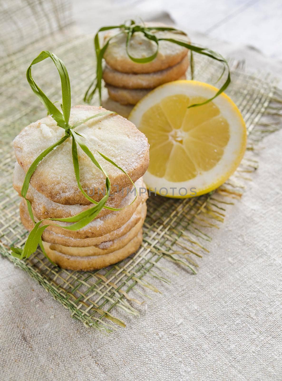 Pile of lemon sugar cookies tied up with rope on linen tablecloth, blurred background From series Winter pastry