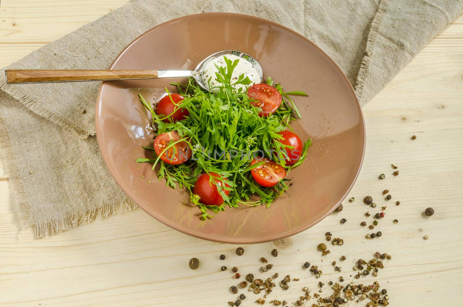 Watercress salad with cherry tomatoes and sour cream. Overhead view. From series Natural organic food