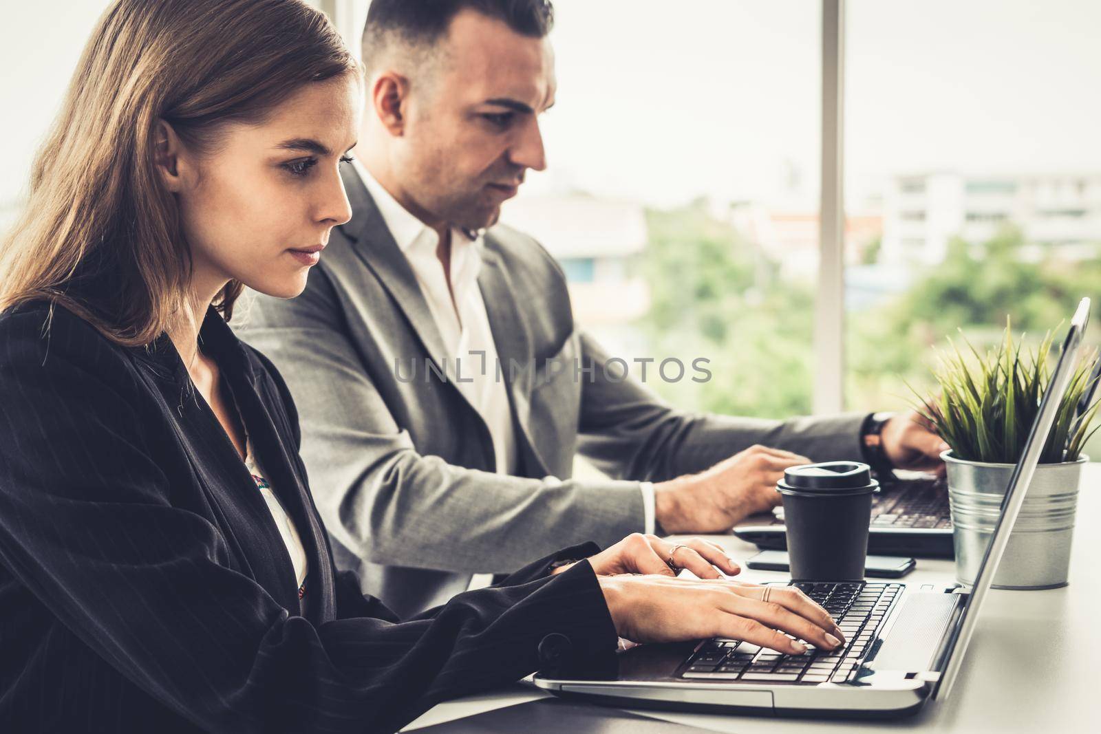 Businessman executive is in meeting discussion with a businesswoman worker in modern workplace office. People corporate business team concept.