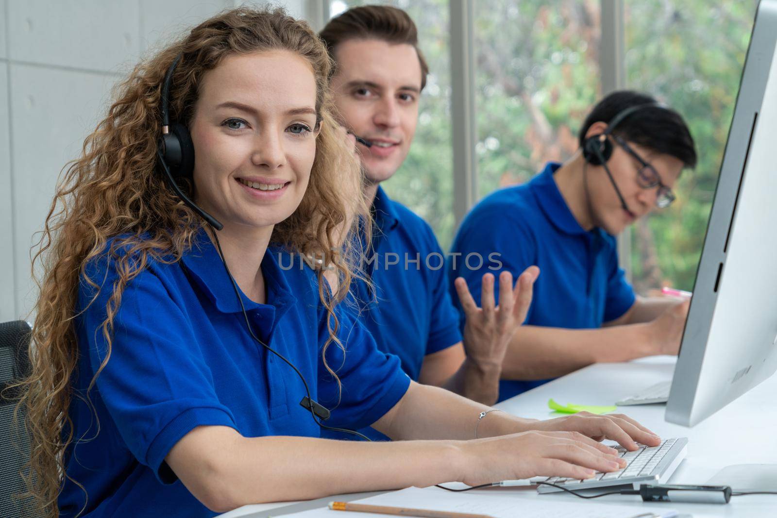 Business people wearing headset working in office to support remote customer or colleague. Call center, telemarketing, customer support agent provide service on telephone video conference call.