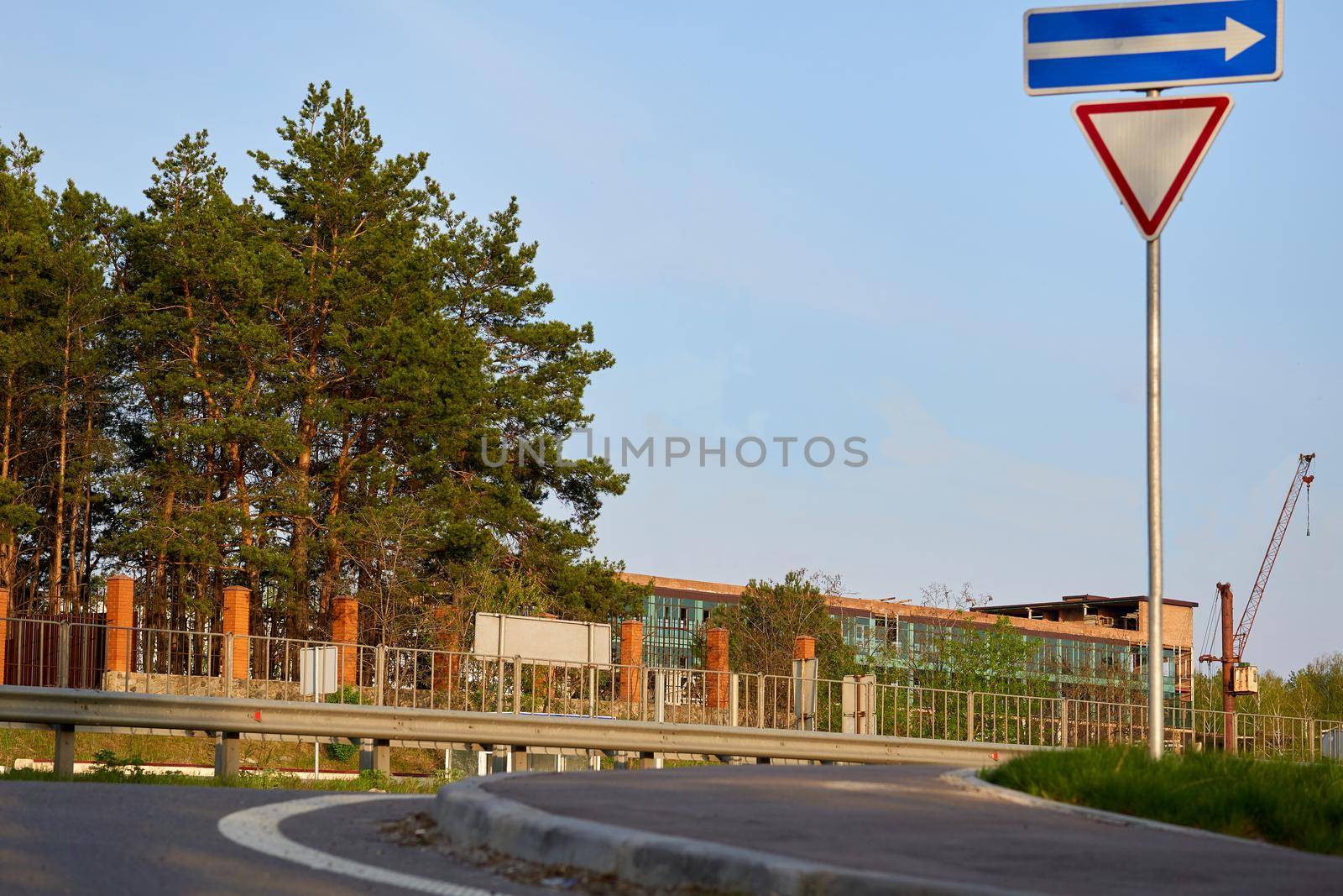 Road turn with warning signs with fence and trees by jovani68