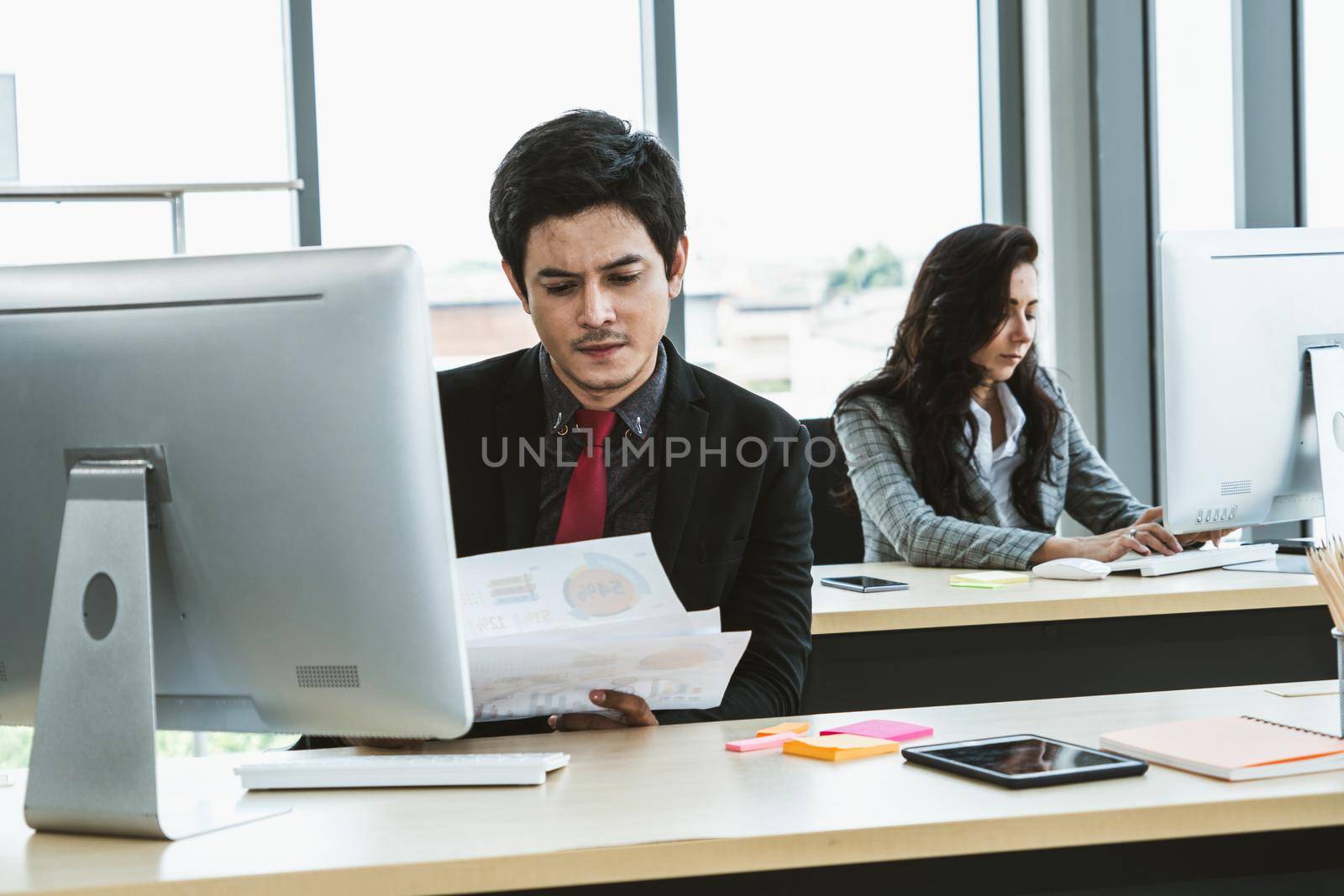 Business people working at table in modern office room while analyzing financial data report .