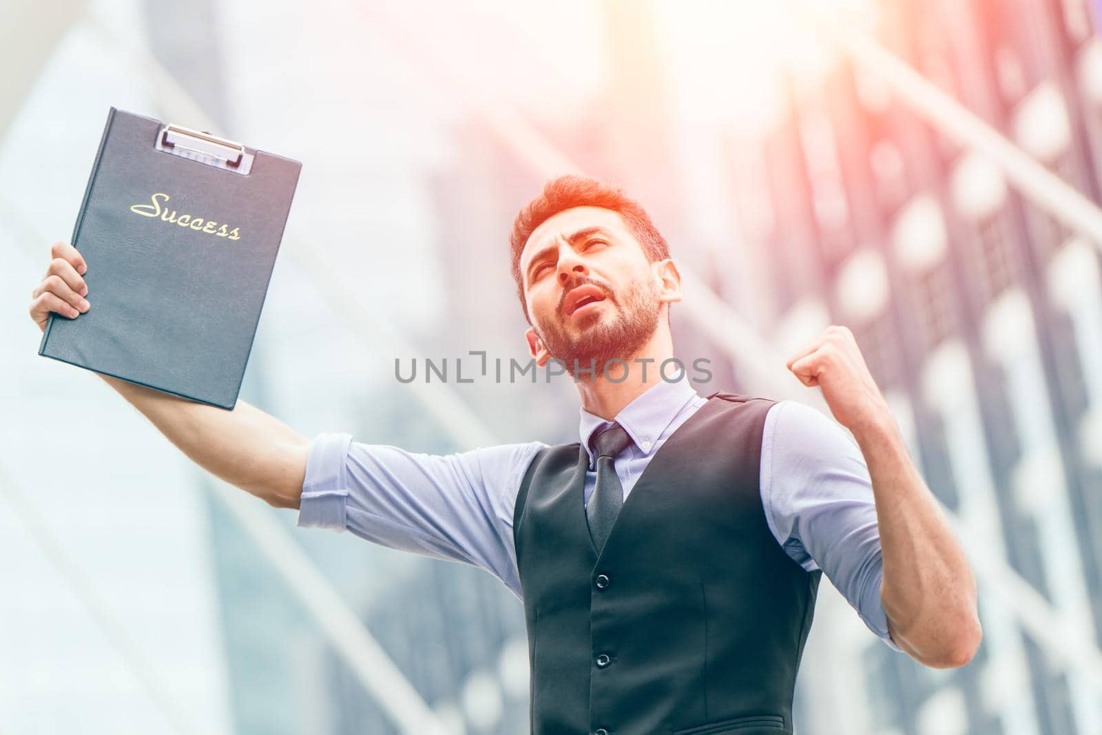 Successful latin businessman glad expression hand rising outdoors at business office outdoors.