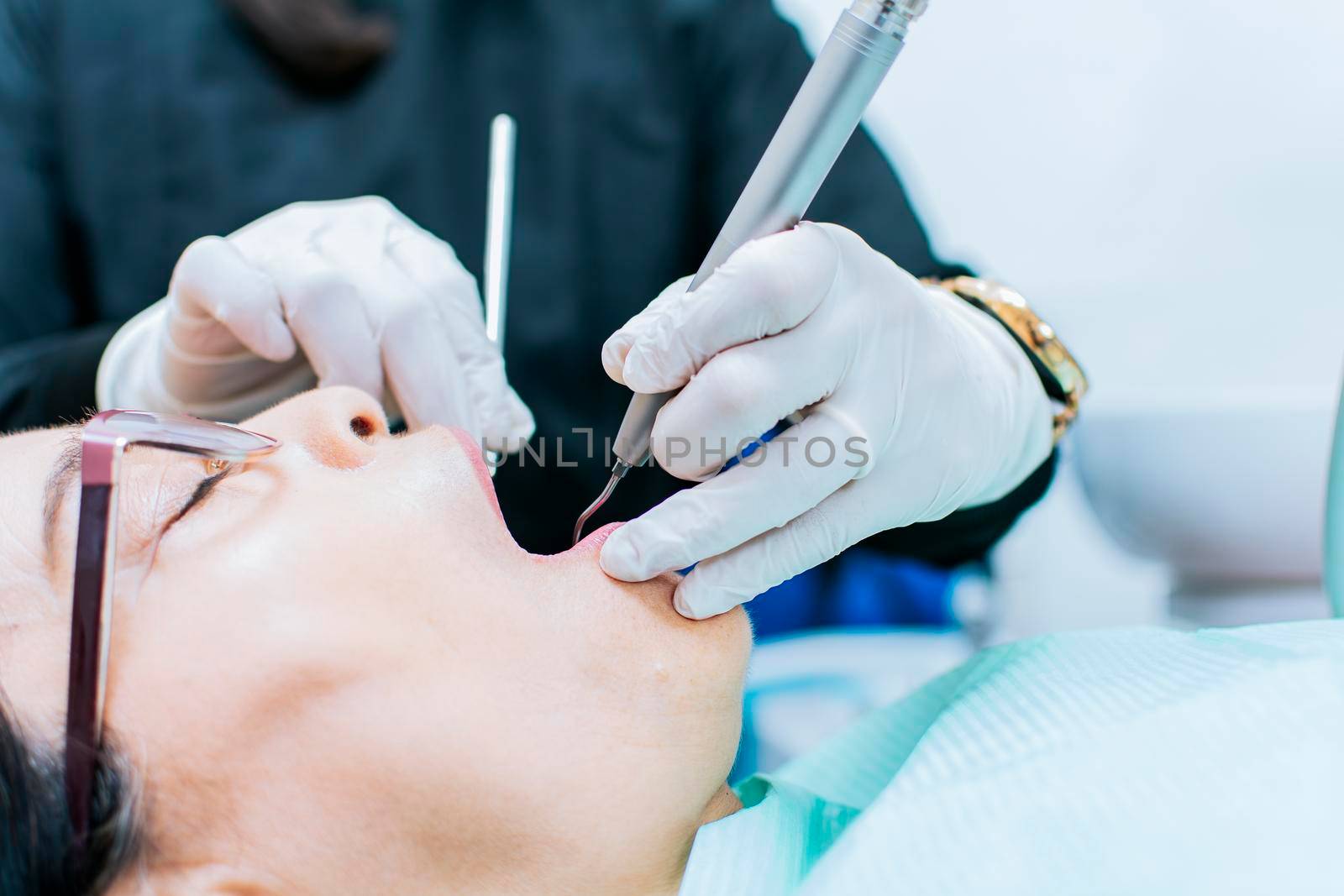 Close up o patient checked by dentist, dentist performing root canal treatment on patient, dentist performing dental checkup by isaiphoto
